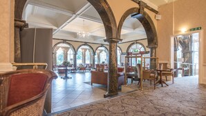 A spacious lobby with high ceilings, arched columns, and large windows. - Cairn Hotel (Harrogate)