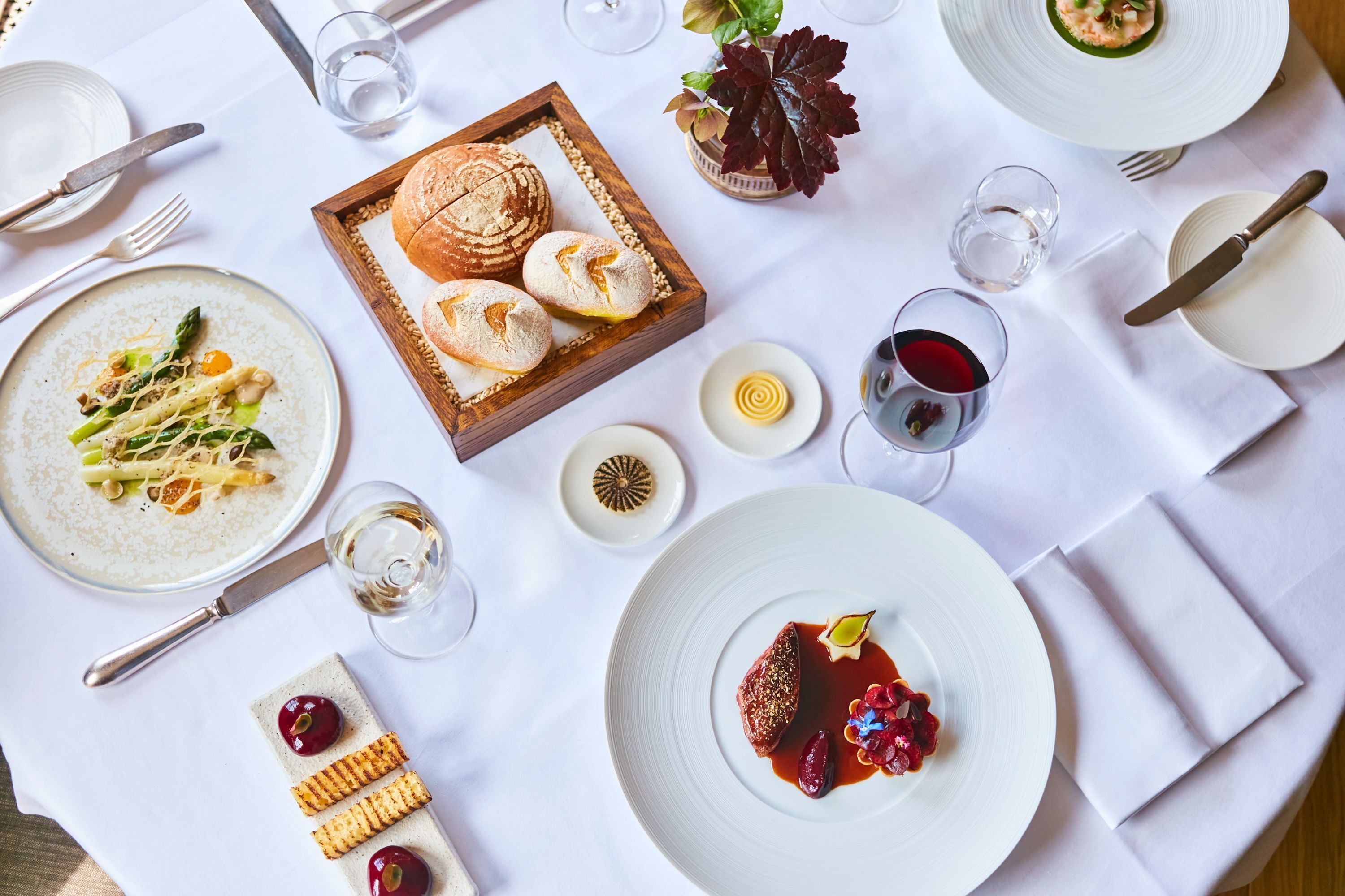 Une table à manger dressée avec différents plats, des verres et des couverts.