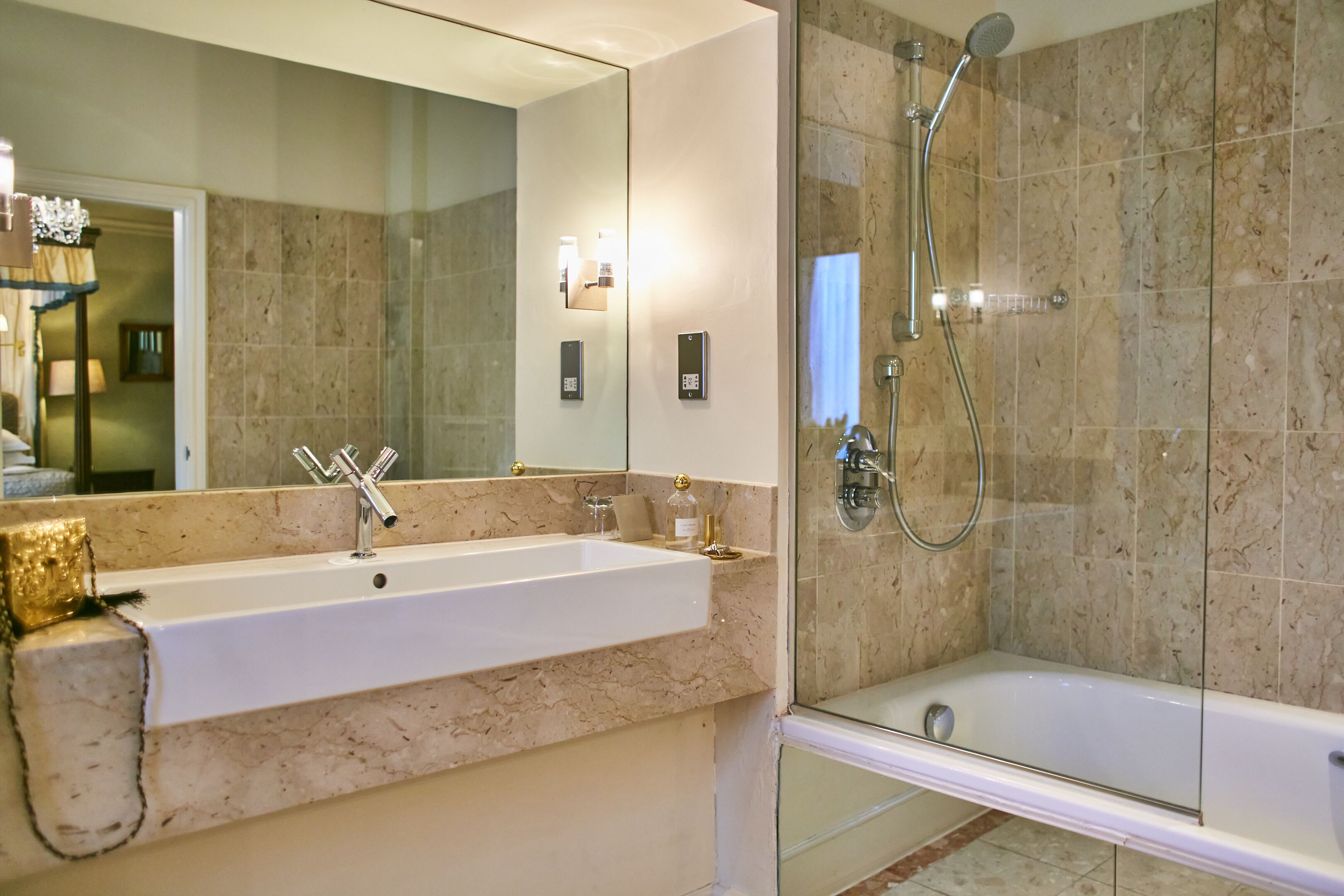A modern bathroom with a large mirror, a sink, a shower, and a bathtub.