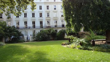 A well-maintained garden with a manicured lawn and various plants.
