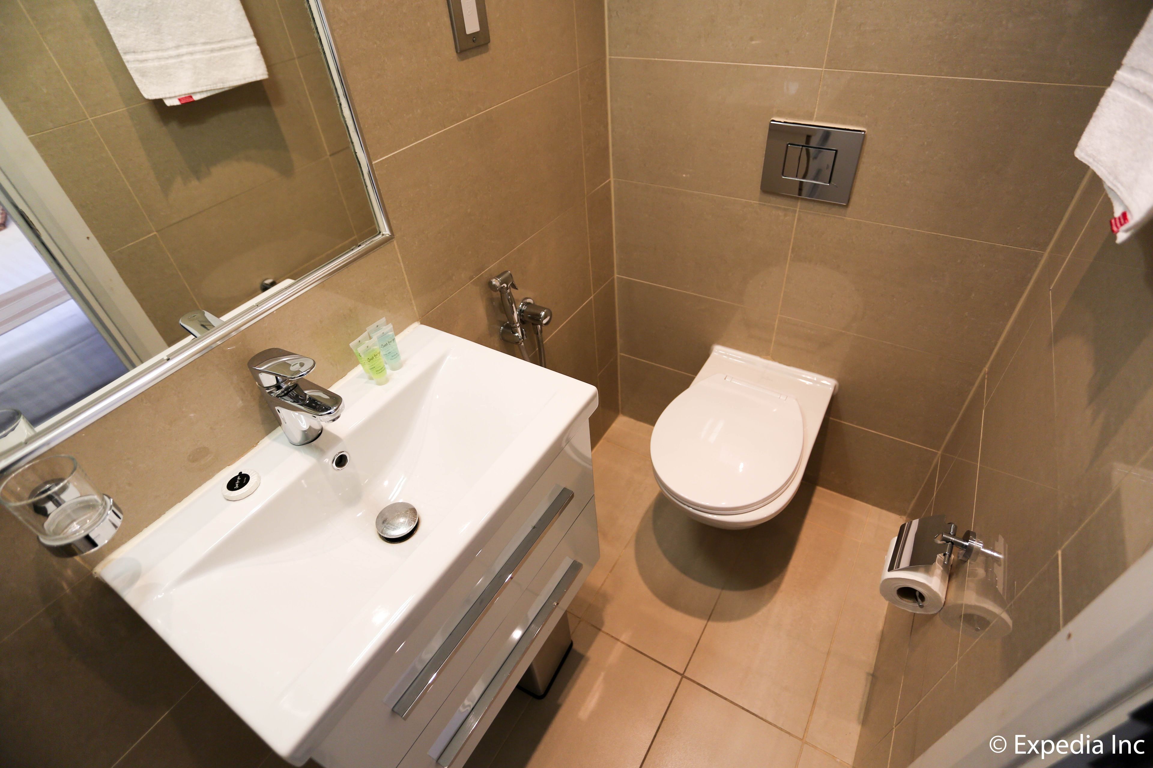 A bathroom with a white sink, a toilet, and a mirror.