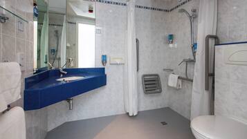 A bathroom with a blue sink, a toilet, and a shower area.