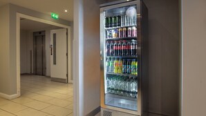 A vending machine with various drinks and snacks in a hotel corridor. - Holiday Inn Express Birmingham - Oldbury by IHG (Oldbury)