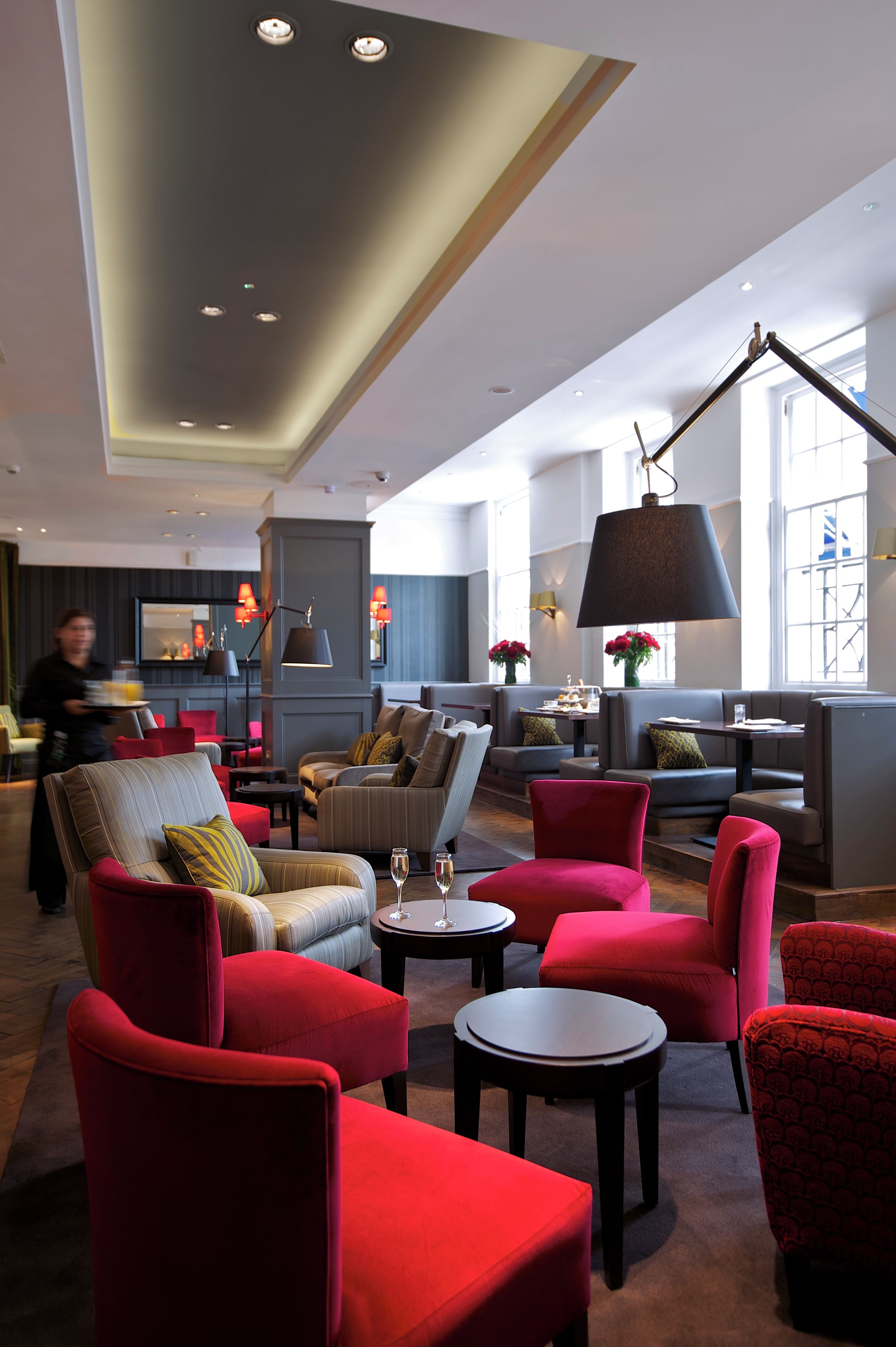 A modern lounge area with seating and a large floor lamp.