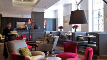 A modern lounge area with seating and a large floor lamp.
