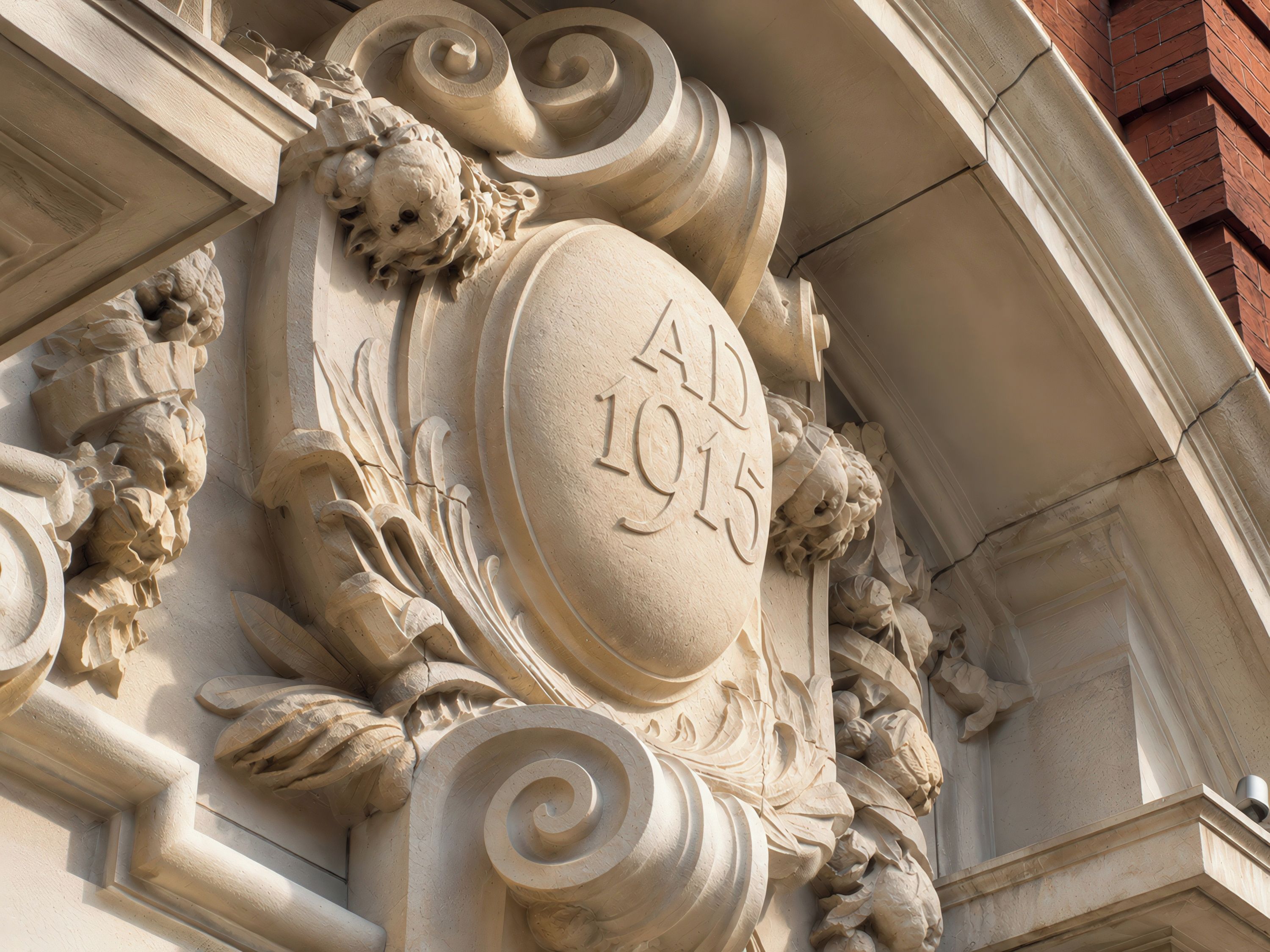 Une façade d’immeuble ornée de sculptures et portant une plaque avec l’inscription « 1915 après J.-C. ».