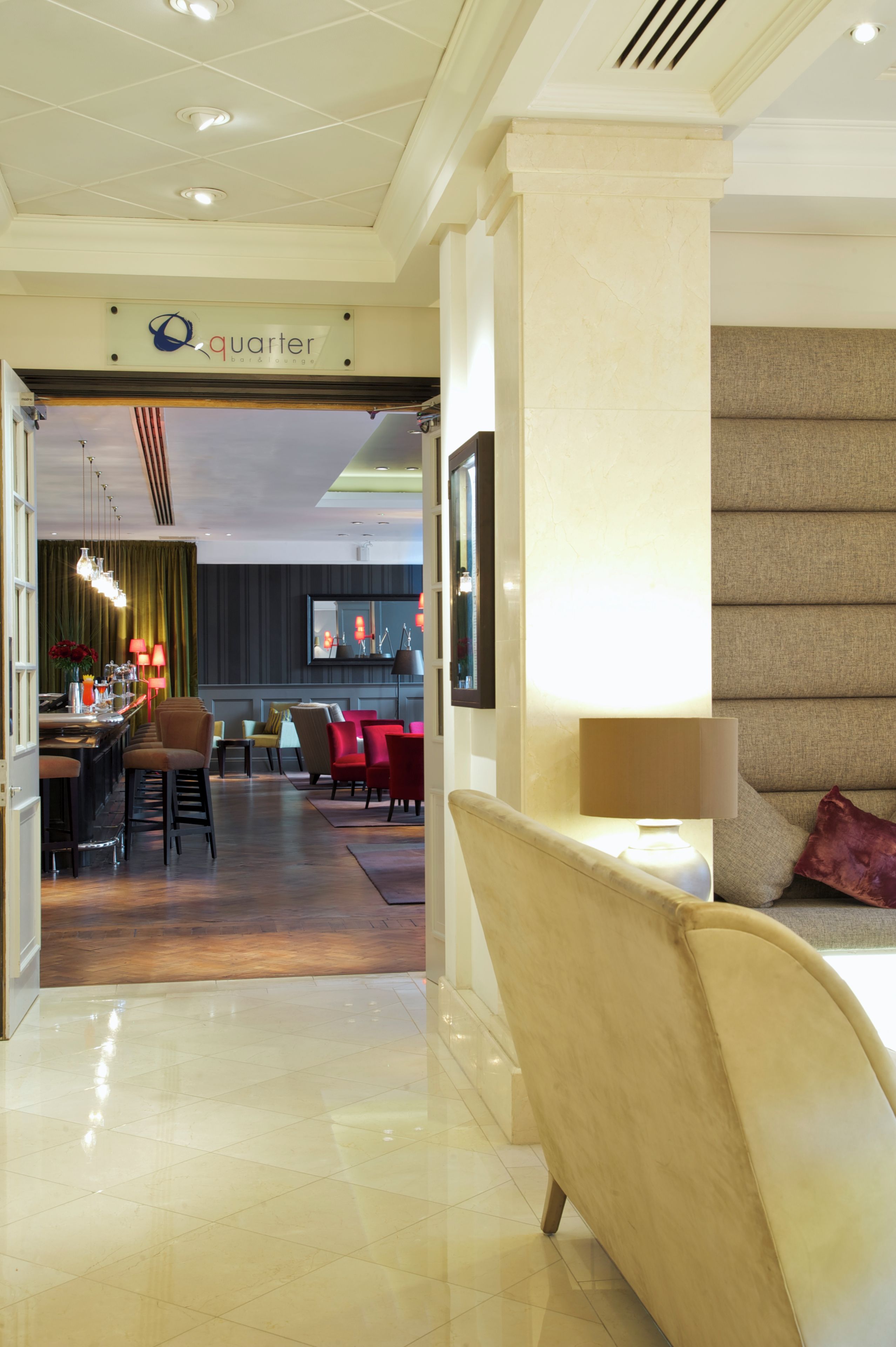 A hotel lobby with a bar/lounge area, seating arrangements, and a modern design.