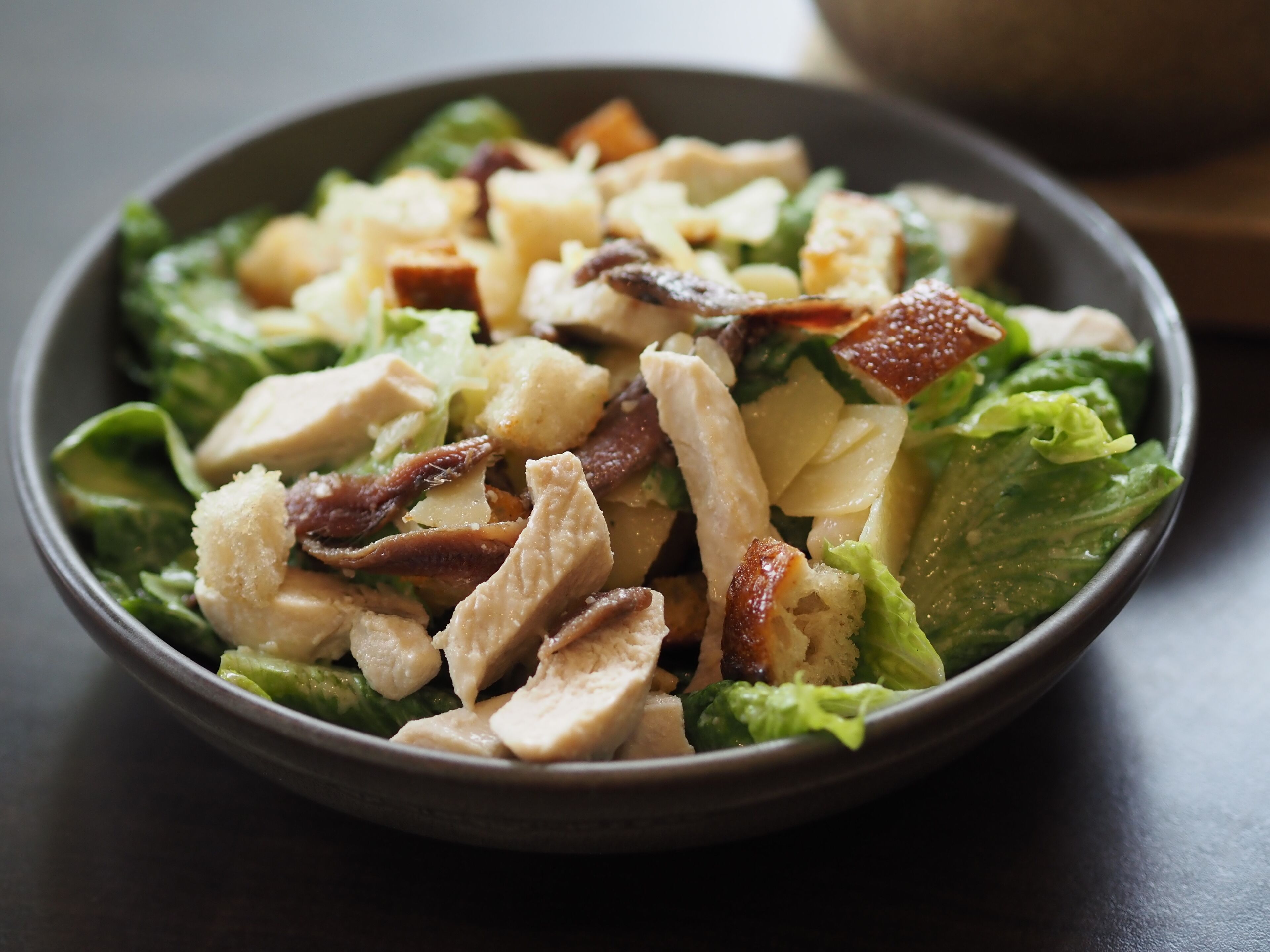 Een salade met sla, kip en spek.