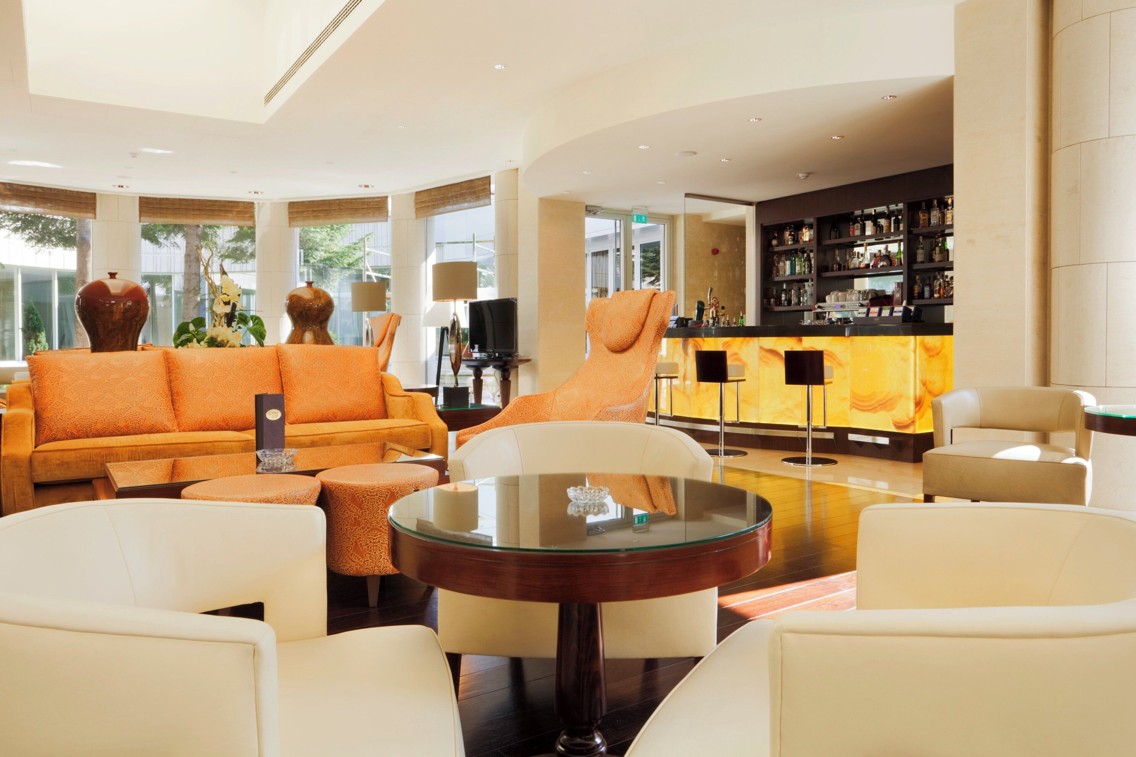 A spacious lobby with a seating area, a bar, and a television.