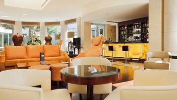 A spacious lobby with a seating area, a bar, and a television.