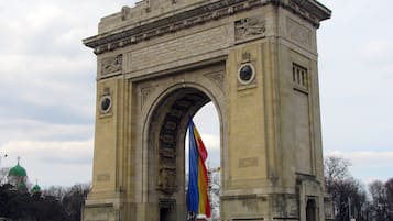 A large stone arch monument with inscriptions and a flag.