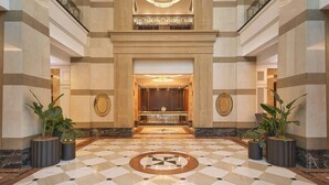 A lobby with a checkered floor, a central chandelier, and two large potted plants. - Brisbane Marriott Hotel (Brisbane)