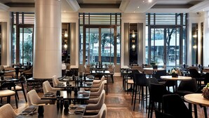 A spacious restaurant with high ceilings, large windows, and modern lighting fixtures. - Brisbane Marriott Hotel (Brisbane)