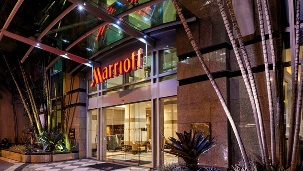 A Marriott hotel entrance with a glass facade, checkered floor, and indoor plants. - Brisbane Marriott Hotel (Brisbane)