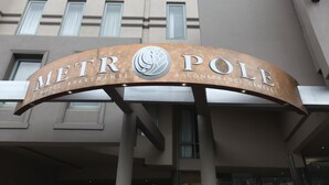 A curved sign with the text "METROPOLE HOTEL APARTMENTS & CONFERENCE CENTRE" above a building facade with large windows. - Melbourne Metropole Central (Fitzroy)
