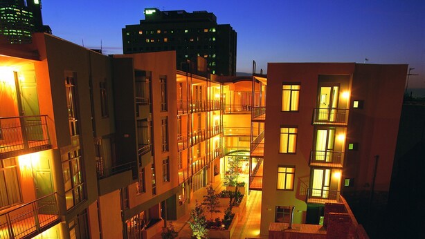 A hotel courtyard with a swimming pool, outdoor seating, and multiple balconies. - Melbourne Metropole Central (Fitzroy)