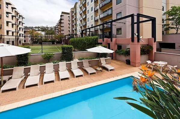 Piscine extérieure, parasols de plage, chaises longues