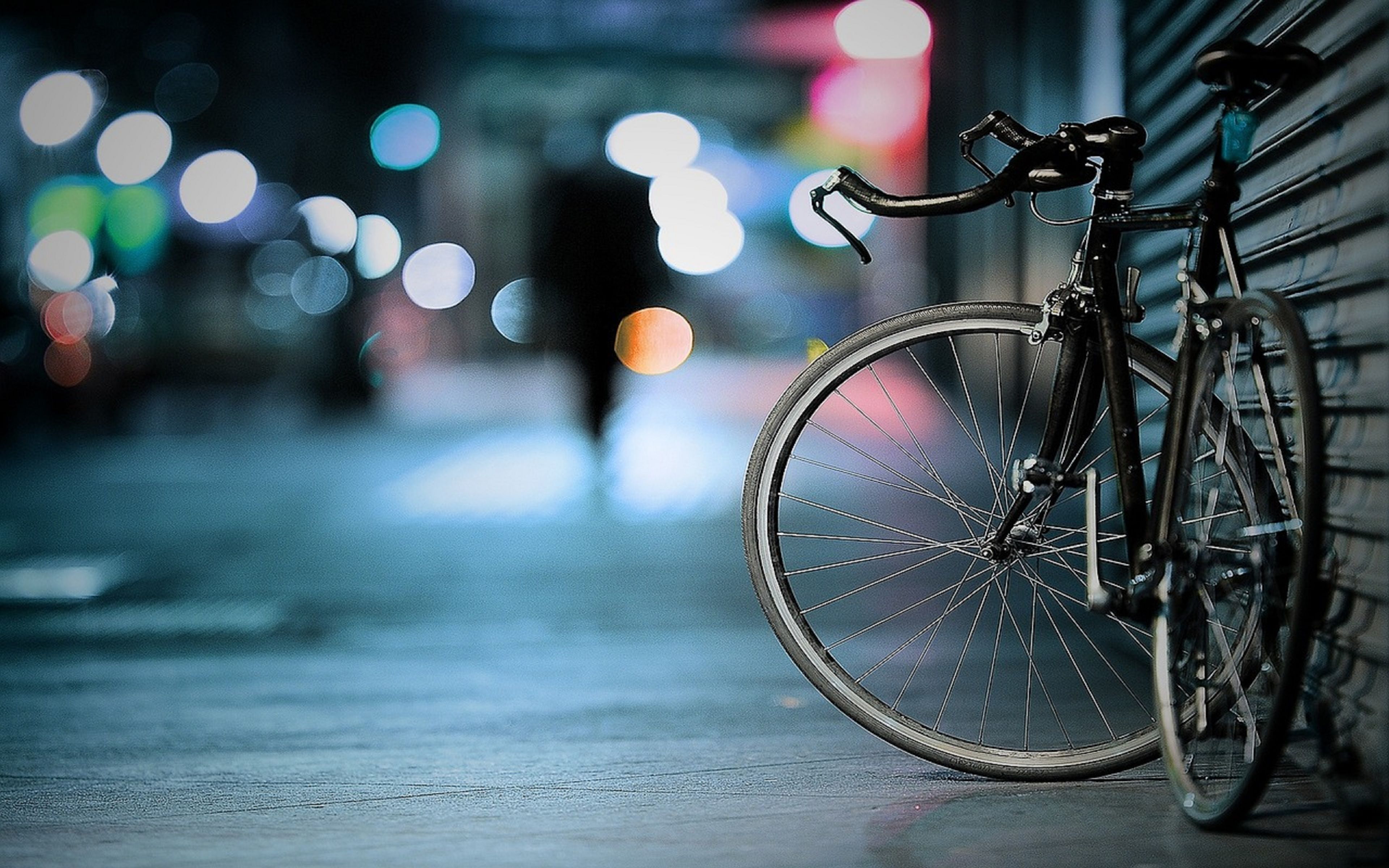 A bicycle leaning against a wall in an urban setting.