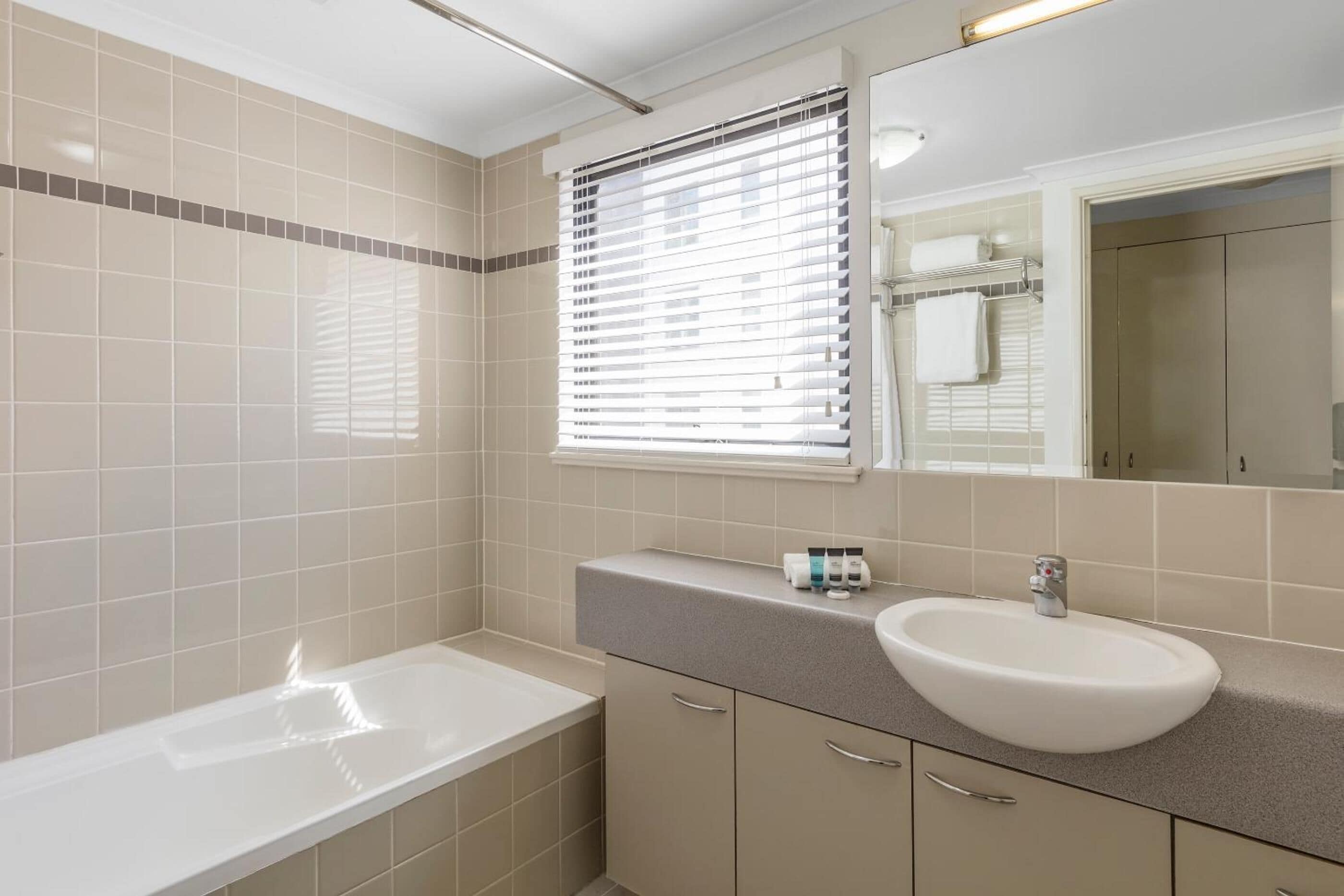 Un baño moderno con bañera, lavabo y tocador con espejo.