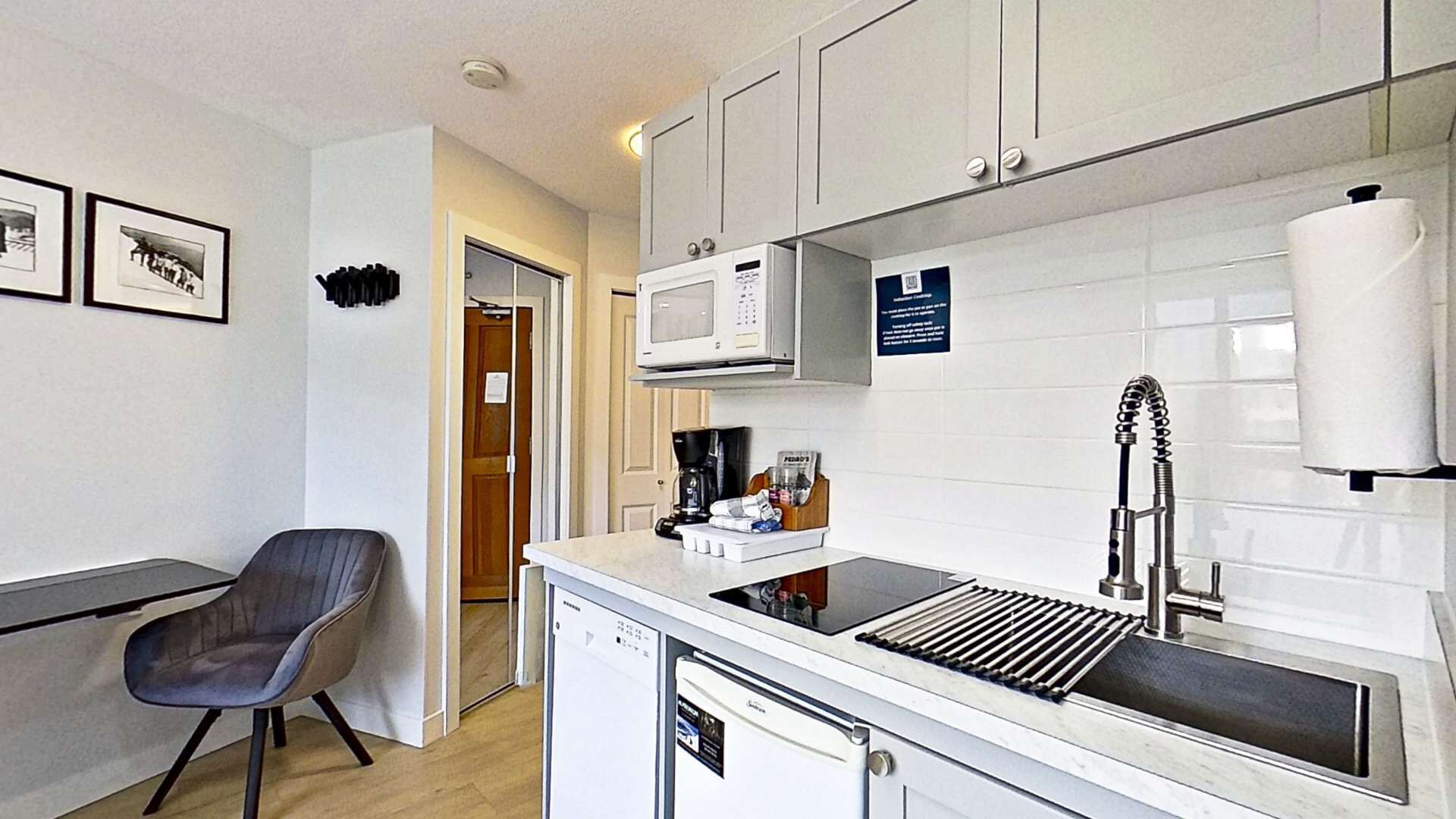 Una cocina compacta con microondas, cafetera y lavabo.
