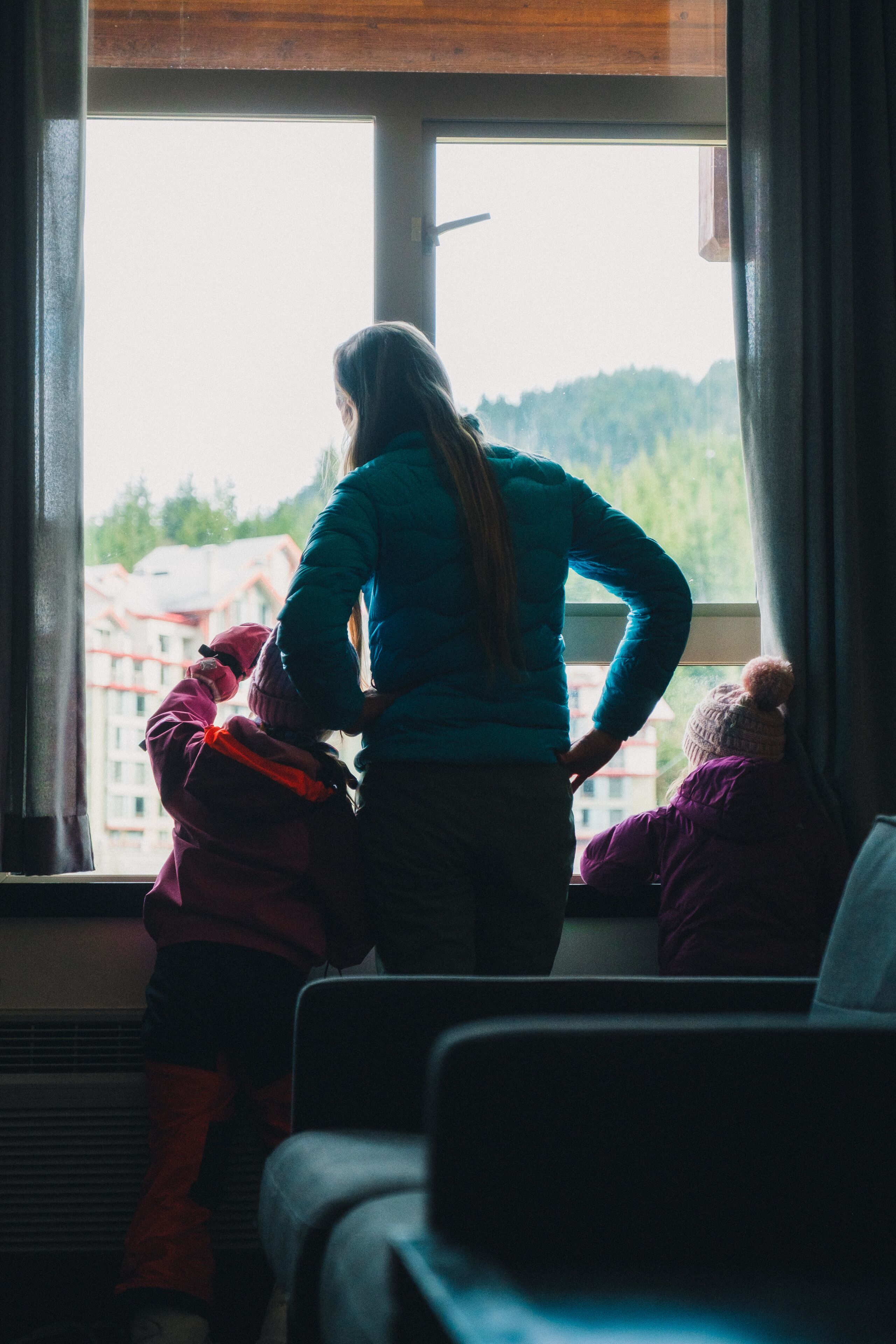 Ein Zimmer mit großem Fenster, Heizung und Blick auf umliegende Gebäude.