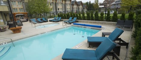 A swimming pool with lounge chairs and a no diving sign.