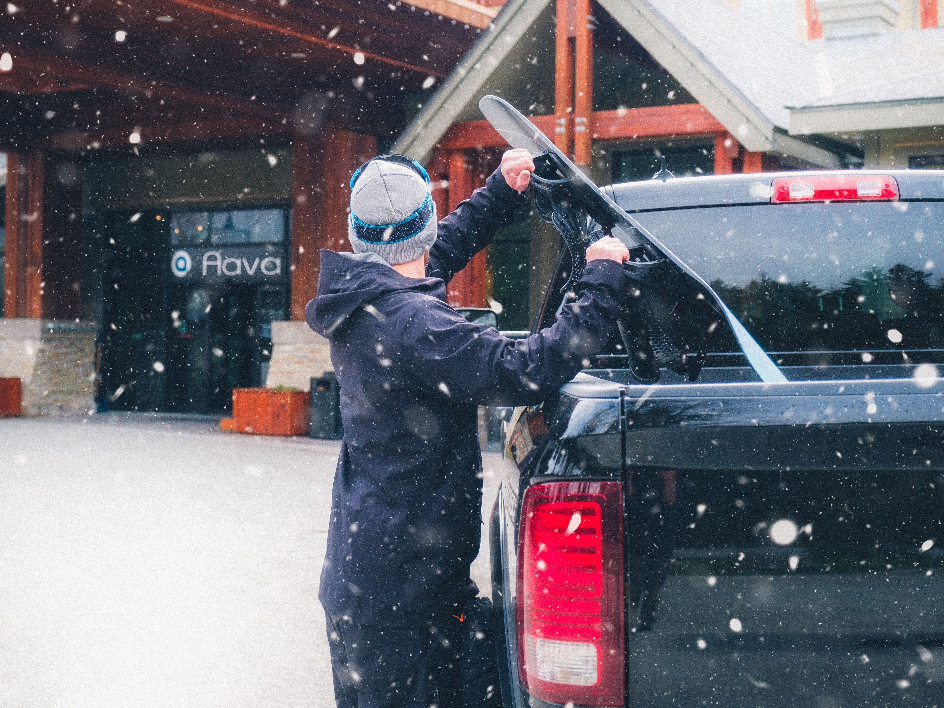 A person loading skis into the back of a vehicle.