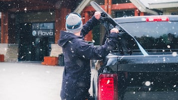 A person loading skis into the back of a vehicle.