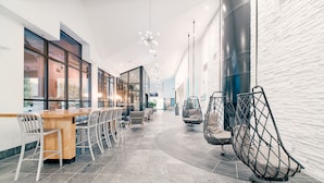 Un intérieur moderne avec un long comptoir, des sièges et des chaises suspendues.