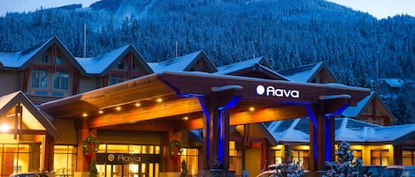 Un hôtel avec une façade en bois, une entrée couverte et une enseigne sur laquelle on peut lire « Hava ».