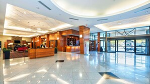 A spacious lobby with a reception desk, seating area, and a large glass entrance. - Grand Park Hotel Vancouver Airport, an Ascend Collection Hotel (Richmond)