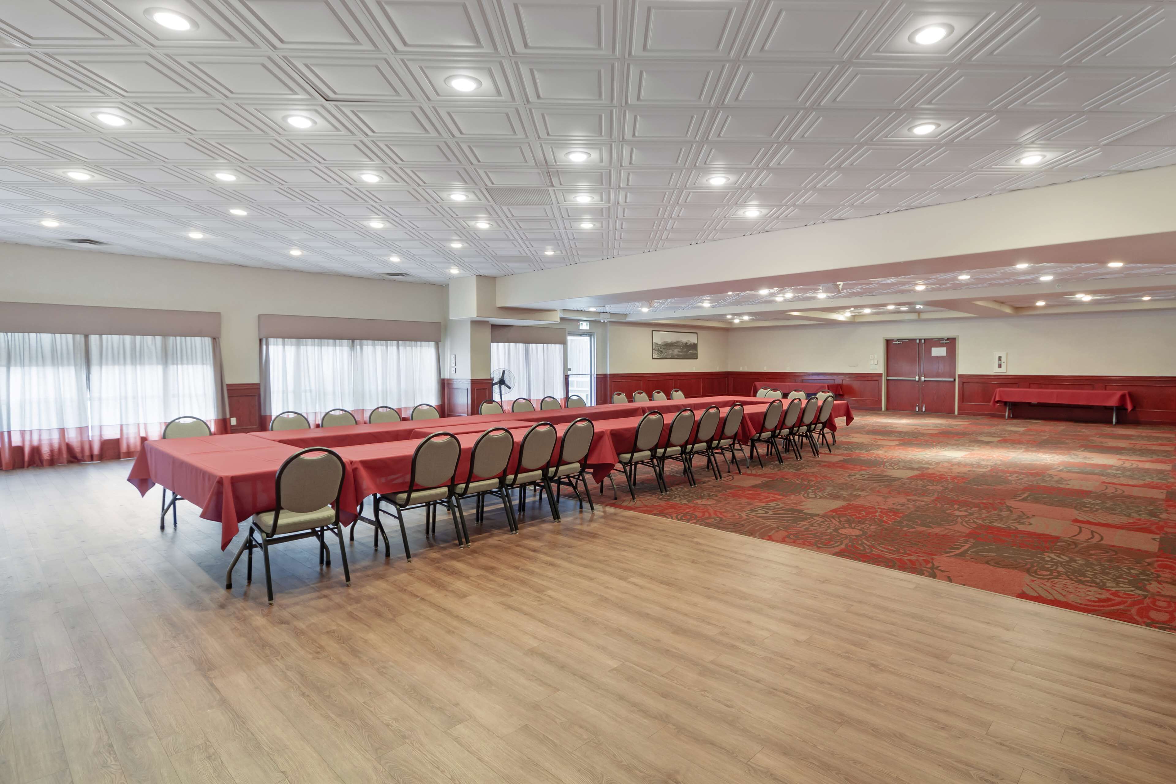 A conference room with a long table, chairs, and a patterned carpet.