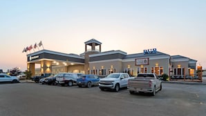 A commercial building with a 'PUB' sign, a 'Best Western' sign, and a 'VINE' sign. There are several vehicles parked in front.