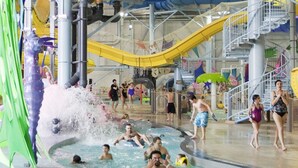 An indoor water park with multiple slides, pools, and a large water feature.