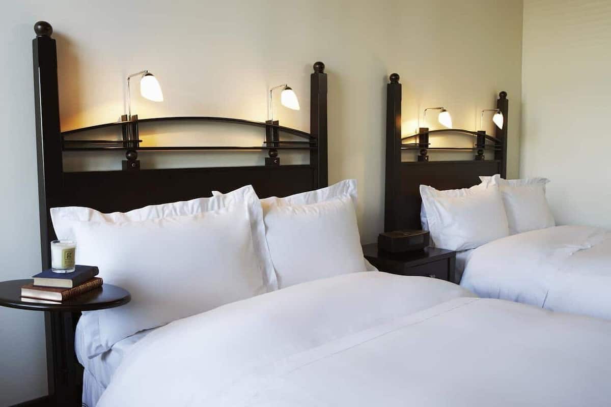 A hotel room with a large bed, two bedside tables, and a nightstand.