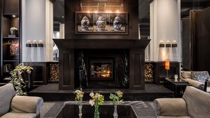 Un moderno hall con chimenea, sofás y una mesa de centro.