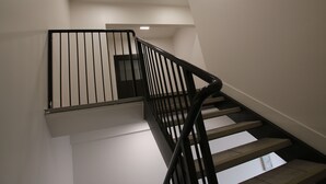 Una escalera moderna con barandas negras y paredes blancas.