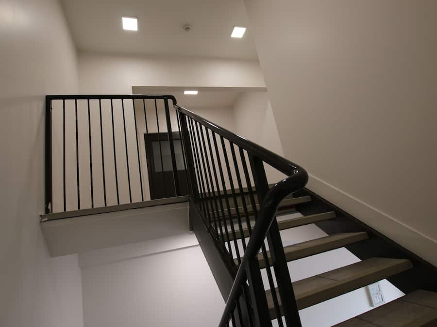 Una escala moderna amb baranes negres i parets blanques.