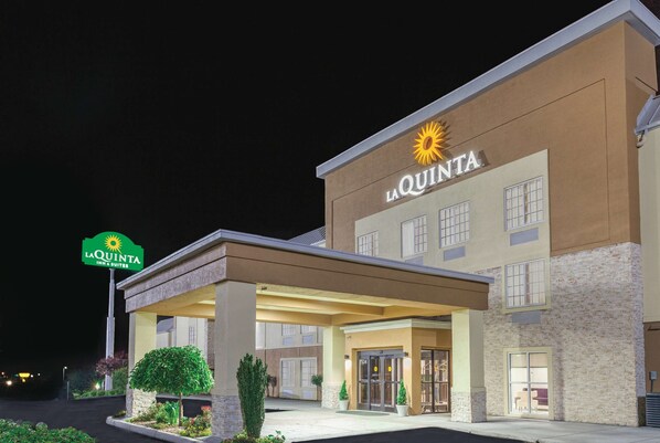Un hôtel La Quinta Inn & Suites doté d’une entrée bien éclairée, d’un espace extérieur abrité et d’une enseigne.
