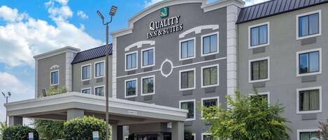 A hotel with a modern design, featuring a prominent sign for "Quality Inn & Suites" and a covered entrance.