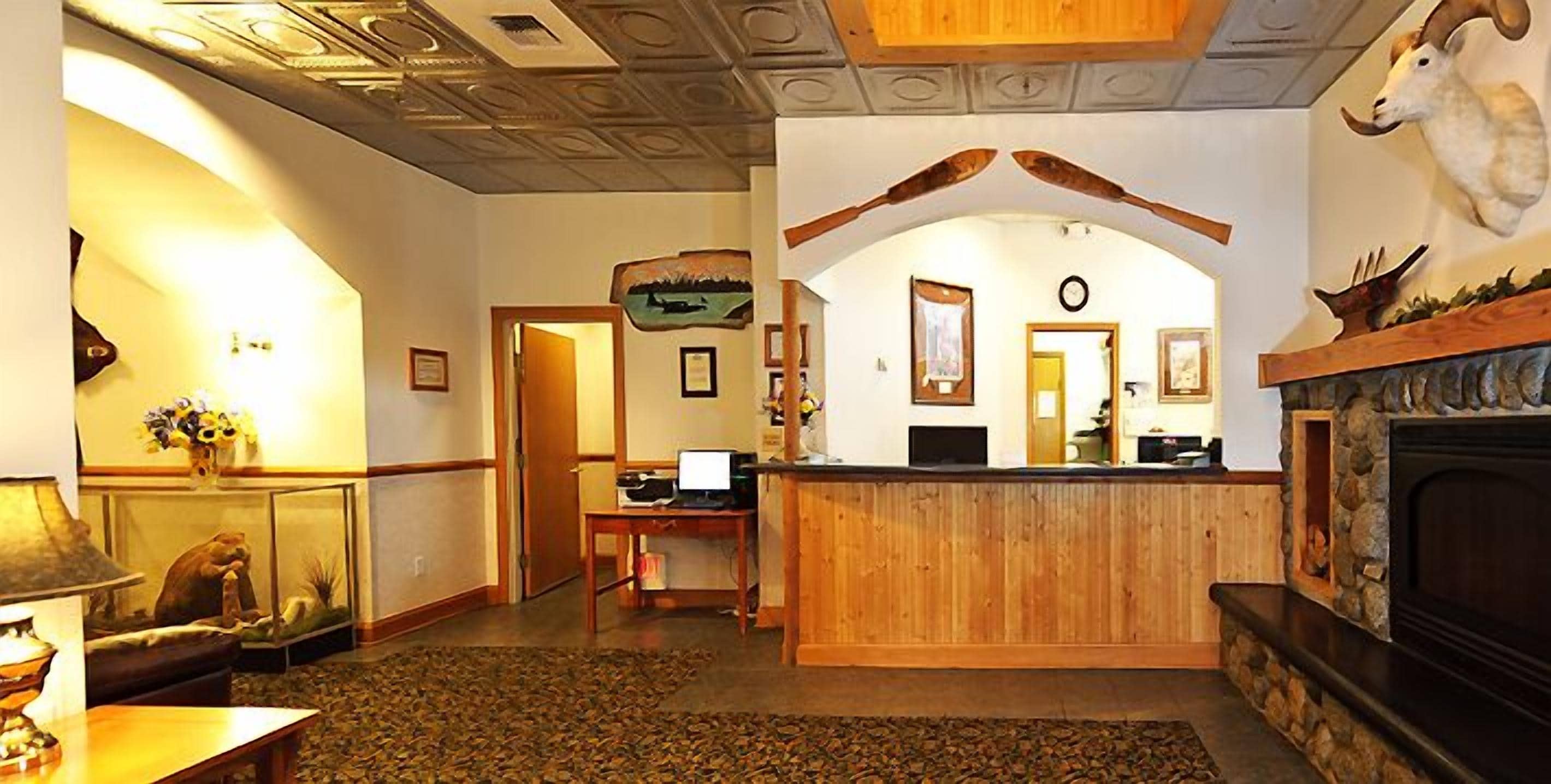 A lobby with a reception desk, a fireplace, and a large mirror.