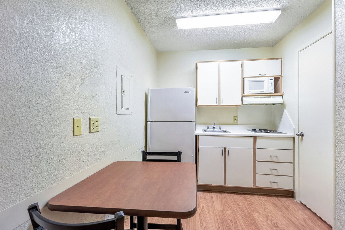 A compact kitchen with a refrigerator, microwave, and a small countertop.