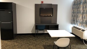 A compact room with a kitchenette, a desk, a chair, and a radiator. - Studio 6 Killeen, TX (Killeen)