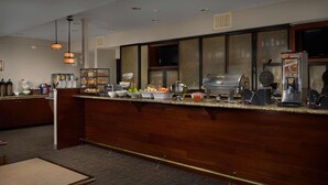 A hotel reception area with a counter, buffet, and seating area. - Country Inn & Suites by Radisson, Portland International Airport, OR (Portland)