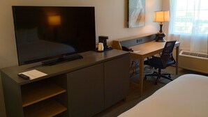 A hotel room with a bed, a desk with a computer, a TV, a lamp, and a painting on the wall. - Country Inn & Suites by Radisson, Portland International Airport, OR (Portland)