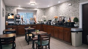 Una cocina moderna con salpicadero de piedra, armarios de madera y una estación de café.