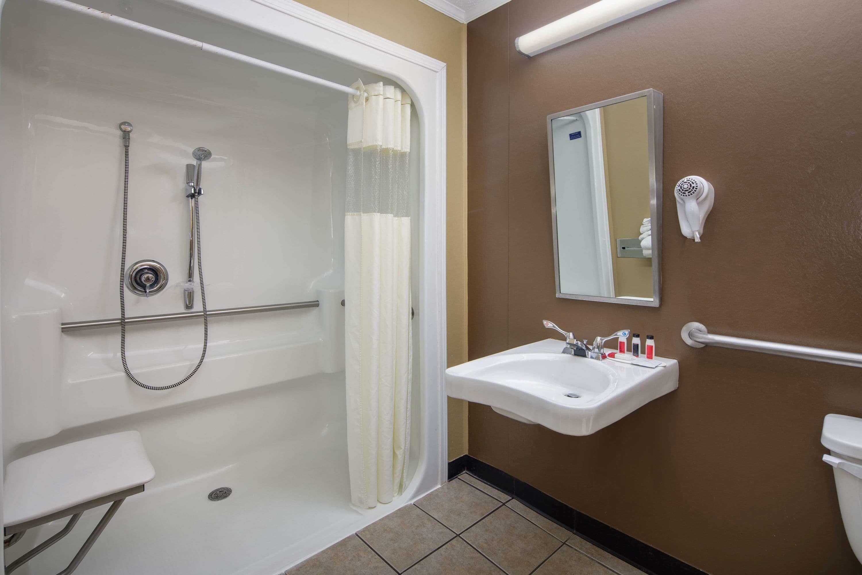 Un bagno con vasca, lavabo, specchio e asciugacapelli.