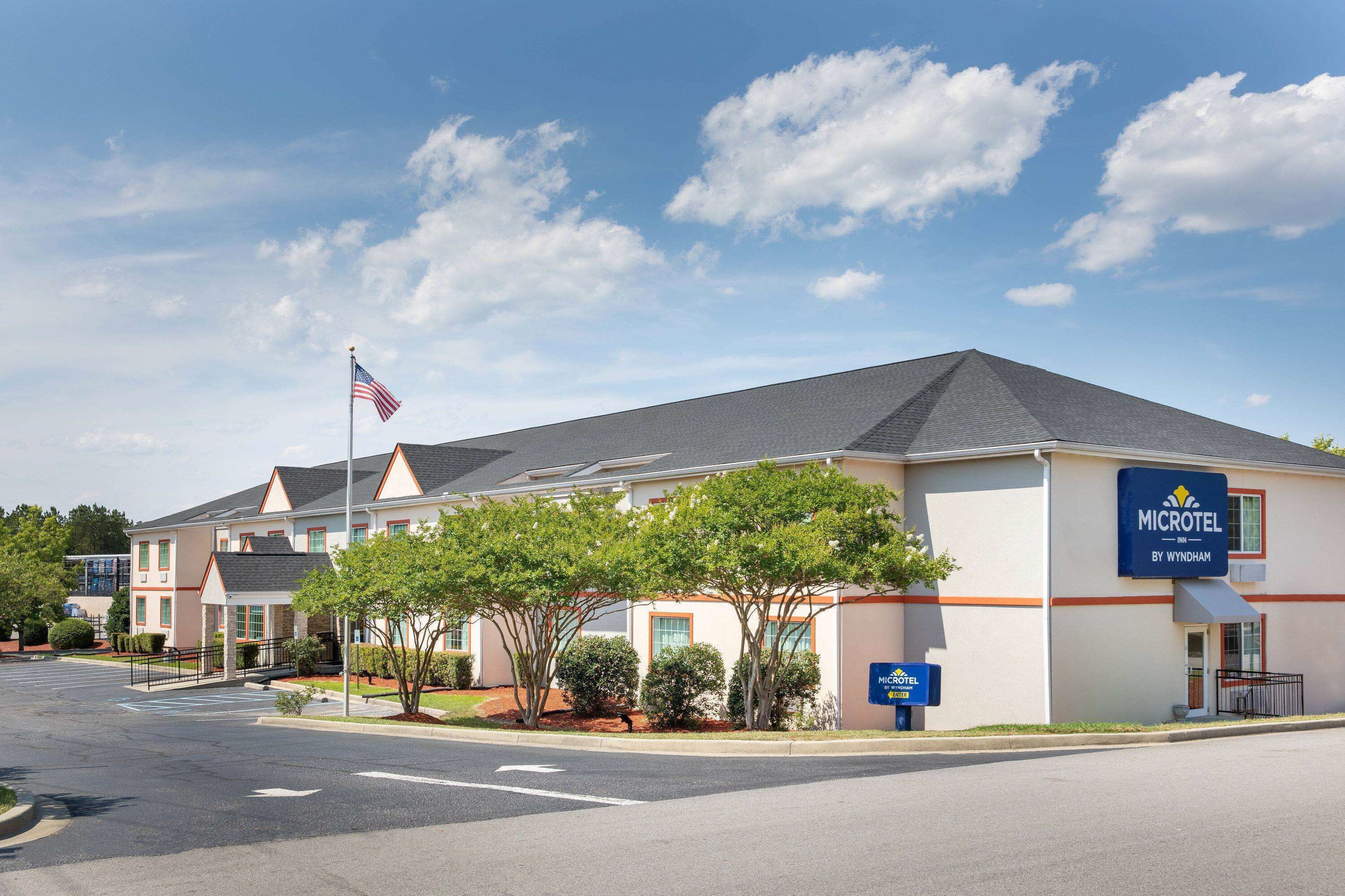 A Microtel Inn by Wyndham with a parking lot, flag, and signage.
