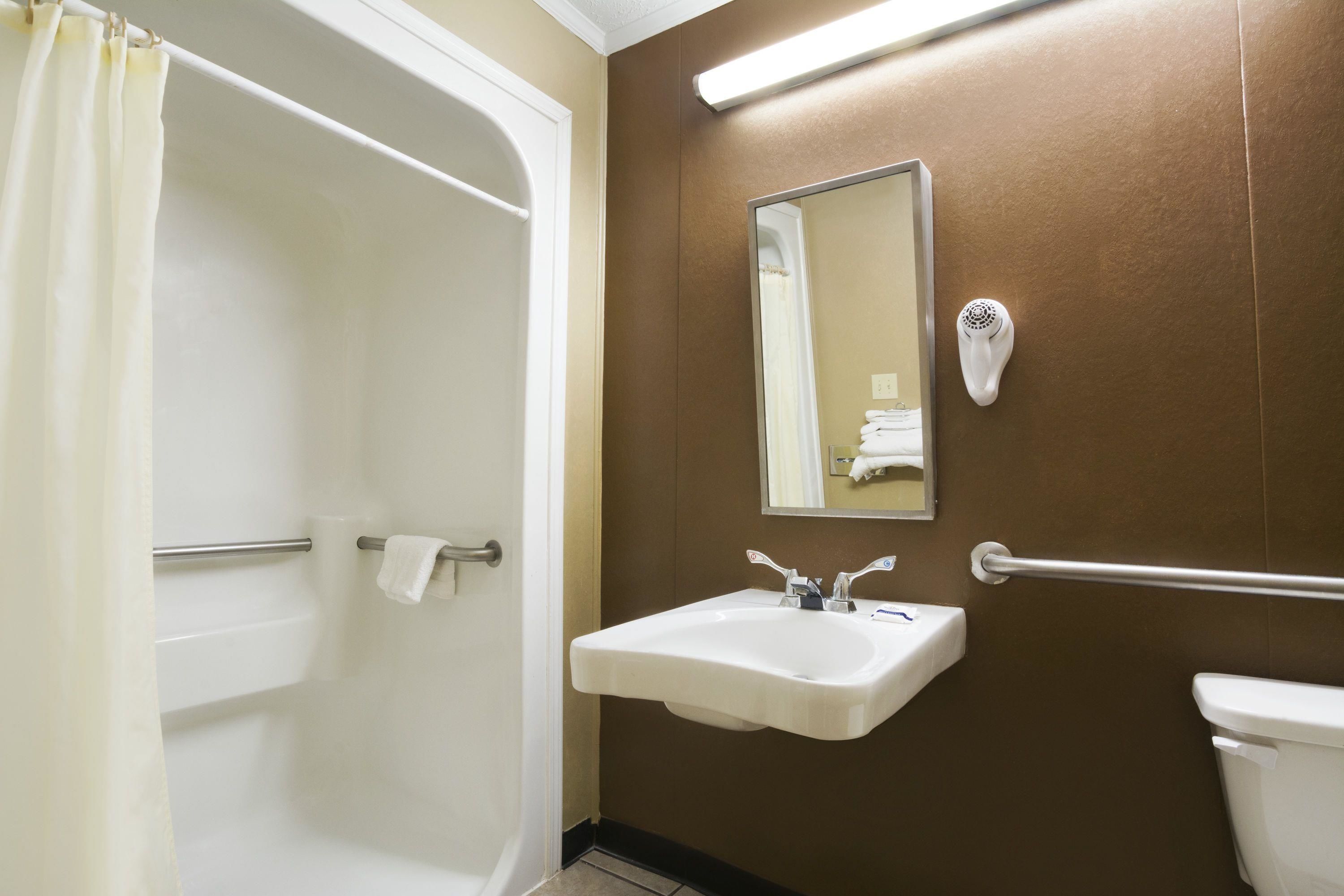 Une salle de bain avec une baignoire, un lavabo, un miroir et des toilettes.
