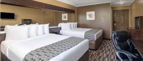 Une chambre d’hôtel avec deux lits, un bureau, une chaise, un téléviseur à écran plat et une porte.